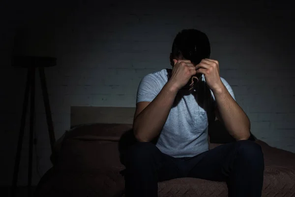 Hombre deprimido con insomnio que lucha contra el trastorno de estrés postraumático - foto de stock