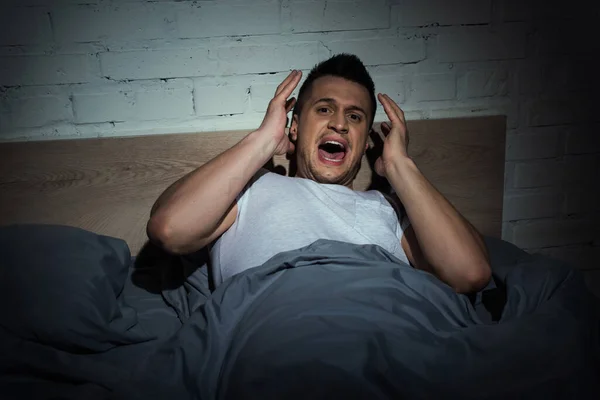 Uomo stressato con attacchi di panico urlando mentre ha incubo di notte — Foto stock