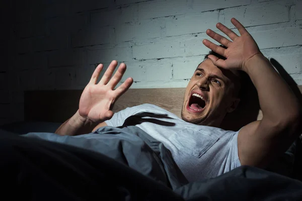 Наляканий молодий чоловік з ptsd має кошмари і кричить вночі — стокове фото
