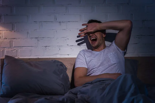 Scared young man with ptsd having nightmares and screaming at night — Stock Photo