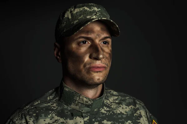 Soldat avec la saleté sur le visage debout en uniforme et casquette souffrant de ptsd isolé sur gris — Photo de stock