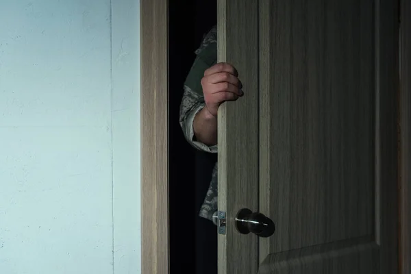 Vista recortada del militar en uniforme militar abriendo la puerta mientras entra en la habitación - foto de stock