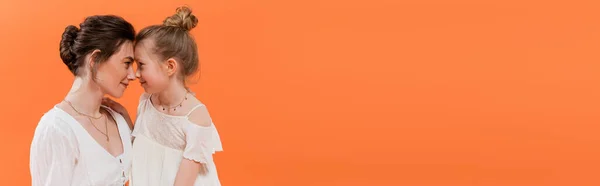 Summer trends, mother-daughter bonding, young woman and preteen girl posing on orange background, white sun dresses, togetherness, fashion and style concept, nose to nose, banner — Stock Photo