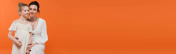 Amor materno, jovem mulher feliz abraçando menina pré-adolescente no fundo laranja, vestidos de sol branco, moda de verão, união, amor, ligação feminina, mãe e filha, banner — Fotografia de Stock