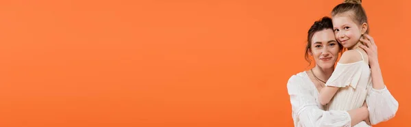 Familienbande, glückliche Mutter und Tochter umarmen sich auf orangefarbenem Hintergrund lächelnd, weiße Sonnenkleider, moderne Elternschaft, Sommermode, Zweisamkeit, Mutter und ihr Kind, Banner — Stockfoto