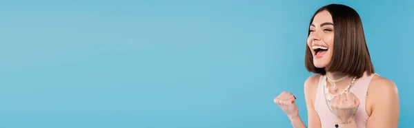 Eccitazione, bruna giovane donna con i capelli corti bruna in canotta sorridente e gestuale con le mani su sfondo blu, abbigliamento casual, gen z moda, felicità, tatuaggi, banner — Foto stock