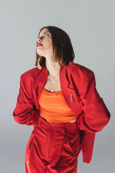 Dame in Rot, junge brünette Frau mit kurzen Haaren posiert im Anzug auf grauem Hintergrund, Generation Z, trendiges Outfit, modisches Modell, professionelle Kleidung, Führungsstil — Stockfoto