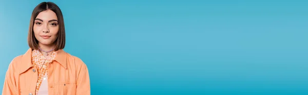 Generation z, Porträt einer charmanten Frau, junges Modemodel, das auf blauem Hintergrund in die Kamera blickt, orangefarbenes Hemd, kurze brünette Haare, durchbohrte Nase, Sommeroutfit, Fashionista, Banner — Stockfoto