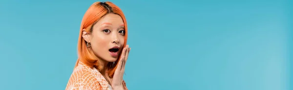 Surprised face, emotional, young asian woman with dyed hair looking at camera with opened mouth on blue background, youth culture, generation z, emotional, hand near face, banner — Stock Photo