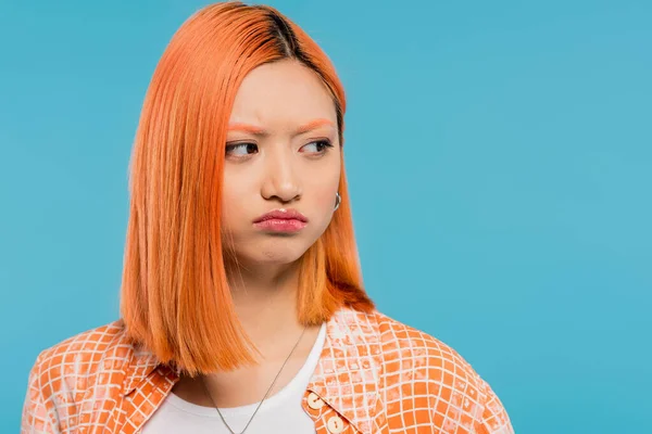 Offended, displeased, upset, young asian woman with red hair looking away and pouting lips on blue background, casual wear, generation z, emotional, upset, sad face — Stock Photo