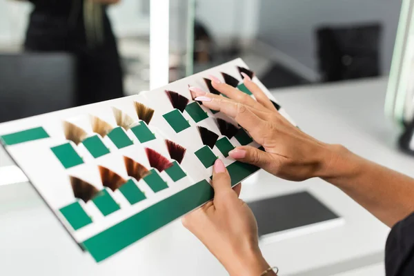 Cropped, hair professional, beauty worker holding hair color palette in beauty salon, hair extension, hair stylist, salon job, beauty salon work, hair trends, manicure, female hands — Stock Photo