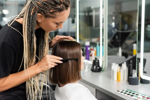 Trabajo de salón, estilista con trenzas cepillado pelo de mujer, peine de pelo profesional, peinado, tratamiento del cabello, peinado, extensión, cliente de salón, profesión de belleza, satisfacción del cliente — Stock Photo