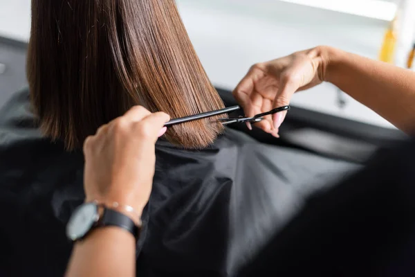 Hairdo, cropped view of hairdresser cutting short brunette hair of female client, holding scissors and comb, professional, beauty worker, haircut, salon job, salon customer — Stock Photo