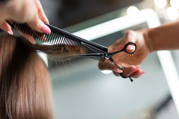 Close up of scissors and professional comb, salon hair tools, cropped view of hairdresser cutting short brunette hair of female client, beauty worker, haircut, salon job, beauty industry — Stock Photo