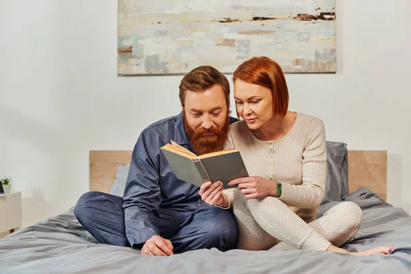 Quality time, reading book together, happiness, day off without kids, redhead husband and wife, bonding, relaxation time, parents alone at home, lifestyle, adult leisure — Stock Photo