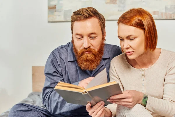 Quality time, reading book together, happiness, day off without kids, redhead husband and wife, bonding, bearded man and woman, relaxation time, parents alone at home, lifestyle, adult leisure — Stock Photo