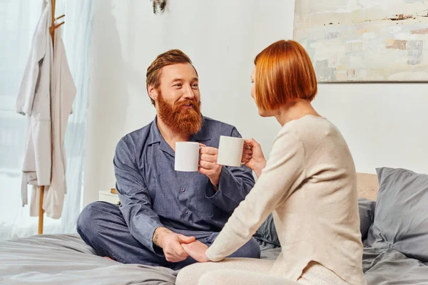 Coffee and conversation, morning rituals, quality time, day off without kids, redhead husband and wife, happiness, bearded man and woman holding cups, parents alone at home, lifestyle — Stock Photo