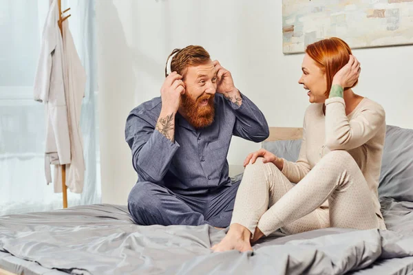 Happiness, excited and bearded man, day off without kids, redhead husband and wife, bearded man in wireless headphones, cheerful parents alone at home, modern lifestyle, listening music — Stock Photo
