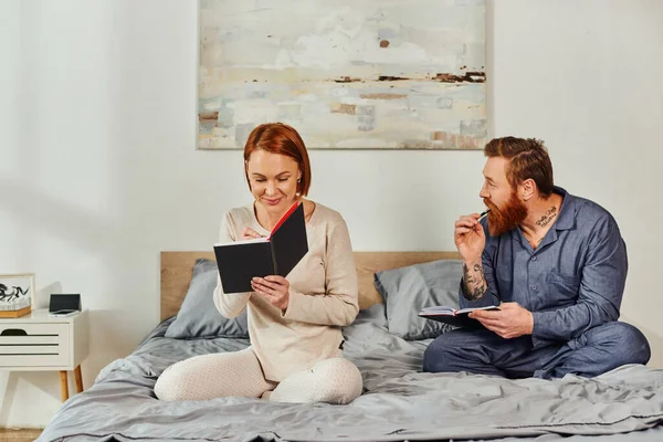 Writing experience, notebook romance, married couple taking notes, day off without kids, redhead husband and wife, enjoying time, day off, weekends together, tattooed, parents alone at home — Stock Photo