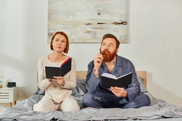 Writing experience, notebook romance, pensive married couple taking notes, day off without kids, redhead husband and wife, enjoying time, day off, weekends together, tattooed, parents alone at home — Stock Photo