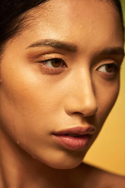 Wassertropfen im Gesicht, Nahaufnahme einer jungen asiatischen Frau mit nasser Haut, die auf grünem Hintergrund wegschaut, Hautfeuchtigkeit, Schönheitskampagne, Perfektion, Wellness, konzeptionelle — Stockfoto