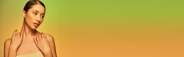 Beleza e cuidados com a pele, mulher asiática bonita com cabelo morena e ombros nus posando no fundo gradiente, verde e laranja, cuidados com a pele, pele brilhante, beleza natural, modelo jovem, banner — Fotografia de Stock