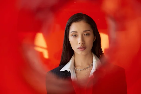 Stylisches Outfit, Modefotografie, junges asiatisches Model in weißem Hemd und Blazer posiert in Handschuhen neben rotem Rundglas, grauer Hintergrund, Blick in die Kamera, moderner Stil, Jugendtrend — Stockfoto