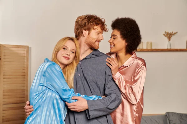 Open relationships, happy man with red hair hugging interracial women, cultural diversity, non traditional partners, multicultural people, acceptance and understanding, happiness — Stock Photo