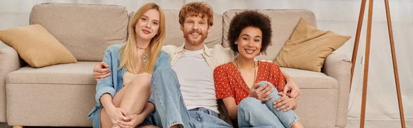 Polygamy, acceptance, group relationship, love triangle, happy multicultural women and bearded man in open relationship, diversity and bonding, non monogamy, three people looking at camera, banner — Stock Photo