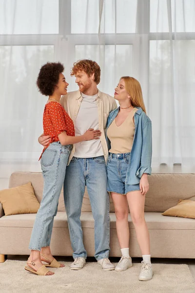 Non traditional relationship, polygamy, three adults, happy redhead man hugging with multicultural women, threesome, cultural diversity, acceptance, bonding and love, multiracial lovers — Stock Photo