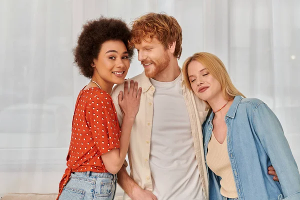 Polygamy, non traditional relationship, three adults, happy redhead man hugging with multicultural women, threesome, cultural diversity, acceptance, bonding and love, multiracial lovers — Stock Photo