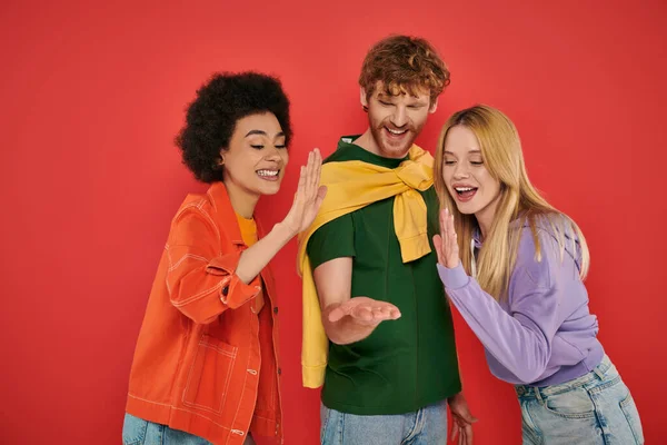 Open relationship, polygamy concept, three interracial lovers giving high five on coral background, cultural diversity, polyamorous, excited multiethnic people having fun — Stock Photo