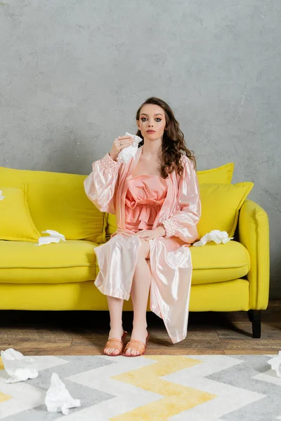 Emotional stress, sad woman with smudged mascara sitting on yellow couch, housewife with crying eyes holding napkin, feeling lonely and depressed, heartbroken wife at home — Stock Photo
