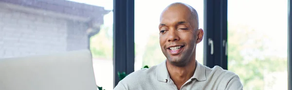 Chronic illness, positive african american businessman with eye syndrome looking at laptop, myasthenia gravis, bold and dark skinned office worker, inclusion, diversity in society, banner — Stock Photo