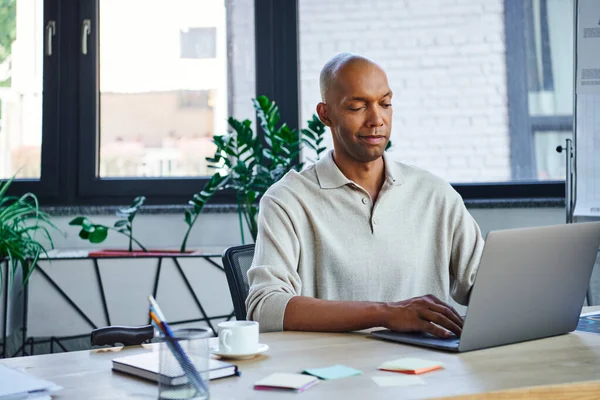 Ptosis, eye syndrome, bold african american businessman using laptop, dark skinned office worker with myasthenia gravis disease, diversity and inclusion, corporate culture, startup — Stock Photo