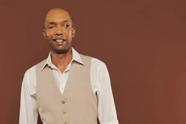 Bold african american man with myasthenia gravis standing on brown background, smiling and looking away, dark skinned, diversity and inclusion, real people, physical impairment — Stock Photo