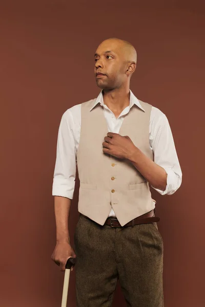 Real people, bold african american man with myasthenia gravis standing with walking cane on brown background, dark skinned, diversity and inclusion, physical impairment — Stock Photo
