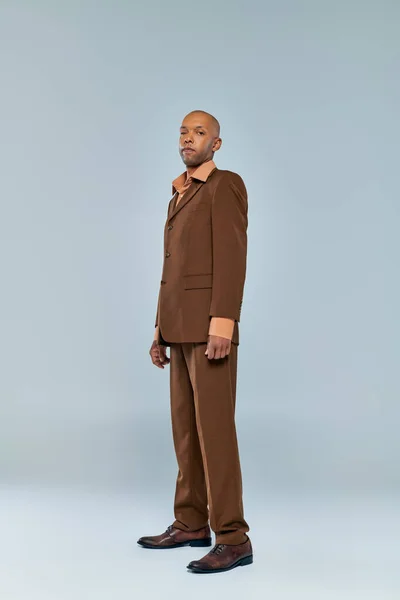 Eye syndrome, bold african american man with myasthenia gravis standing on grey background, dark skinned person in formal wear, diversity and inclusion, real people, full length — Stock Photo