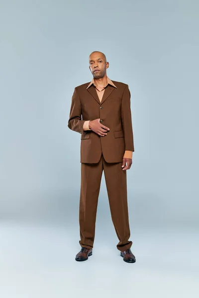 Хронические заболевания, смелый африканский американец с грависом миастении, стоящий на сером фоне, темнокожий человек в формальной одежде, разнообразие и включение, реальные люди, полная длина — стоковое фото