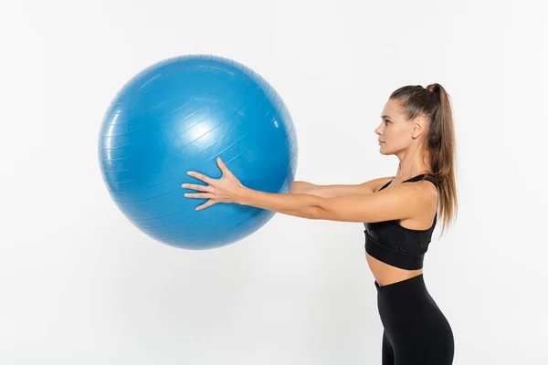 Mujer en forma de desgaste activo sosteniendo pelota de fitness aislado en blanco, concepto de mujer atlética - foto de stock