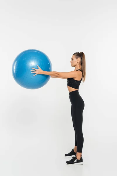 Deportista en forma sosteniendo la pelota de fitness mientras hace ejercicio sobre fondo blanco, concepto de mujer atlética - foto de stock