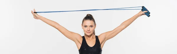Sportswoman ajuste olhando para a câmera enquanto segurando corda salto isolado no branco, banner, conceito de esporte — Fotografia de Stock