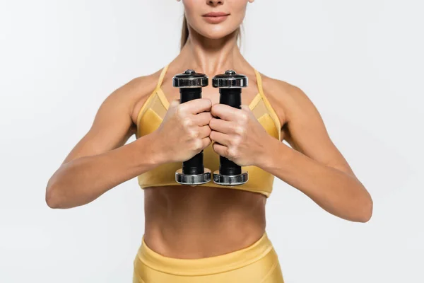 Cropped view of sportswoman in active wear holding dumbbells isolated on white, strength concept — Stock Photo