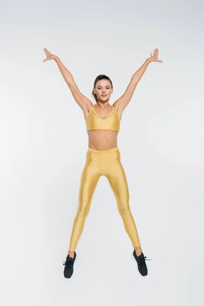Aktiver Lebensstil, Aerobic, Sportlerin in aktiver Kleidung springen auf weißem Hintergrund, sportlich — Stockfoto