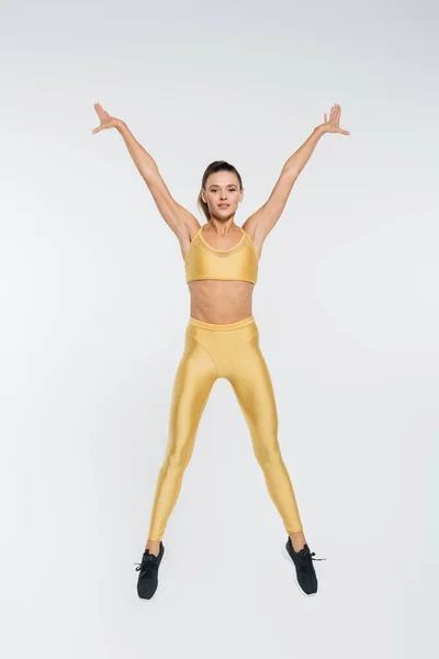 Active lifestyle, aerobics, female athlete in active wear jumping on white background, sporty — Stock Photo