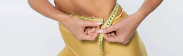 Perda de peso, vista cortada da mulher que mede a cintura com fita adesiva no fundo branco, tamanho do corpo, bandeira — Fotografia de Stock