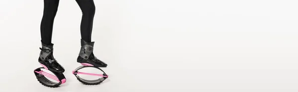Divertente allenamento, colpo ritagliato di donna in kangoo scarpe da salto su bianco, equilibrio e rimbalzo, banner — Foto stock