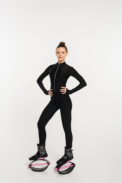 Woman in jumping boots on white background, sportswoman with toned body in black jumpsuit — Stock Photo