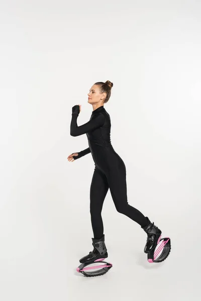 Energia e força, mulher em kangoo sapatos de salto exercendo no fundo branco, botas de salto — Fotografia de Stock
