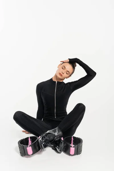 Boots for jumping, sportswoman sitting with crossed legs, kangoo jumping shoes, muscular relaxation — Stock Photo